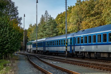 Starkoc CZ 10 19 2024 'te, güneşli bir sonbahar öğleden sonrasında küçük doğu Bohemya istasyonunda trenler.
