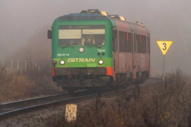 Passenger train in foggy cold morning near station close army area in Polna na Sumave CZ 10 27 2024 clipart