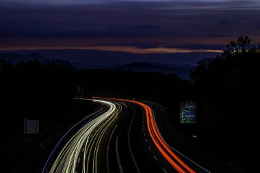 Night on highway and car lines with pedestrian bridge Cat eyes near Chlumec CZ 11 02 2024 clipart