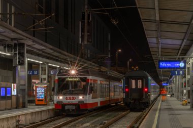 Linz Avusturya 'da trenleri olan modern platformun yakınında gece ve akşam.