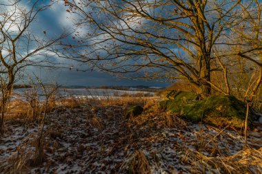 Sunrise with orange sun and winter snowy landscape near Nepomuk Bohemia town clipart