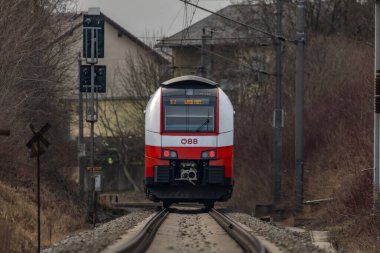 St. Georgen Gusen Avusturya yakınlarındaki bulutlu kış gününde elektrik ünitesi yolcu treni 02 02 2025