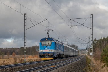 Kışın kara bulutlu bir sabah Tabor CZ 01 31 2025 yakınlarındaki tren rayları ve hızlı tren.