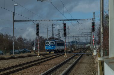 Chotoviny CZ 01 31 2025 yakınlarında kara bulutlu bir kış sabahı tren rayları ve hızlı tren.