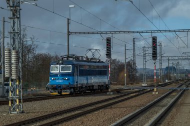 Chotoviny CZ 01 31 2025 yakınlarında kara bulutlu bir kış sabahı tren rayları ve hızlı tren.