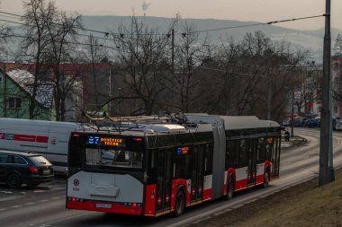 Usti nad Labem CZ 02 22 2025 'te tramvay otobüsüyle mavi saat bulutlu bir kış.