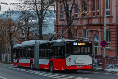 Usti nad Labem CZ 02 22 2025 'te tramvay otobüsüyle mavi saat bulutlu bir kış.