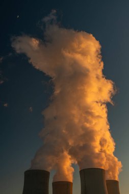 Kışın gün batımında beyaz dumanlı büyük bacalar Güney Bohemya 'da nükleer enerji santrali yakınlarında.