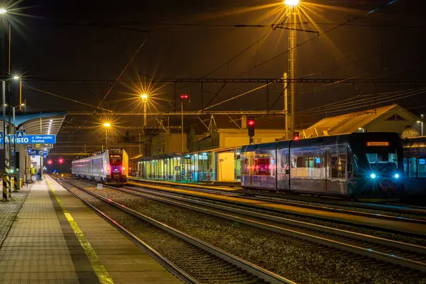 İstasyonda semafor ışıkları ve trenlerle bahar akşamı Mesto CZ 03 28 2025