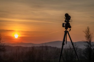 Vysoke nad Jizerou CZ 04 12 2025 yakınlarında gün batımına yakın dağlarda tripodlarda kamera ve mikrofonlar.