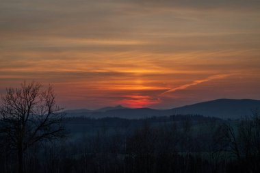 Krkonose 'un kuzey Bohemya dağlarında rengarenk bahar günbatımına sahip halat köyü