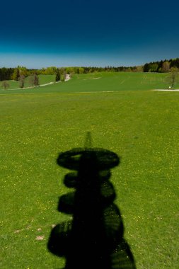 Çek Cumhuriyeti 'nin Orlicke dağlarındaki yeşil çayır üzerinde gözcü kulesi gölgesi