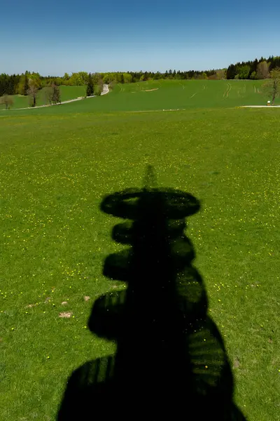 Çek Cumhuriyeti 'nin Orlicke dağlarındaki yeşil çayır üzerinde gözcü kulesi gölgesi