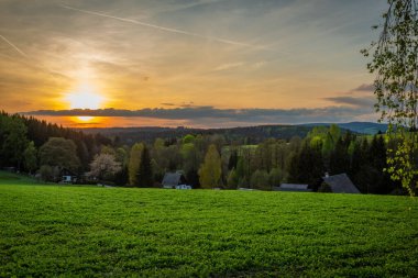 Cihak CZ 04 30 2025 yakınlarında güneşli bir akşamda yeşil taze ormanlar ve çayırlar ile Orlicke dağlarında renk ilkbahar manzarası