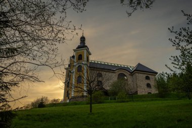 İlkbahar akşamı Neratov CZ 04 29 2025 'te kilise ve köy evlerinin vitreous çatısı