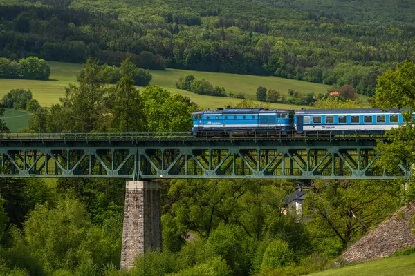 Eski viyadük Holubov yakınlarındaki Cesky Krumlov 'a giden mavi yolcu treni CZ 05 17 2025