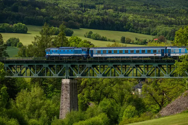 Eski viyadük Holubov yakınlarındaki Cesky Krumlov 'a giden mavi yolcu treni CZ 05 17 2025