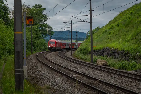 Weng Avusturya yakınlarındaki yaz bulutlu bir akşamda Avusturya trenleriyle elektrik hattı. 06: 25