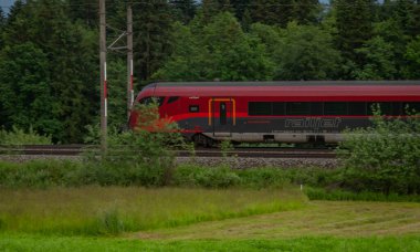 Weng Avusturya yakınlarındaki yaz bulutlu bir akşamda Avusturya trenleriyle elektrik hattı. 06: 25