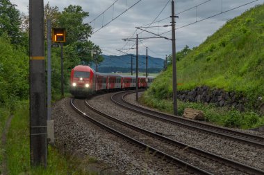 Weng Avusturya yakınlarındaki yaz bulutlu bir akşamda Avusturya trenleriyle elektrik hattı. 06: 25