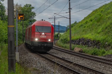 Weng Avusturya yakınlarındaki yaz bulutlu bir akşamda Avusturya trenleriyle elektrik hattı. 06: 25