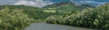 Pfarrwerfen yakınlarında bulutlu bir yaz gününde mavi suyla Salzach nehri