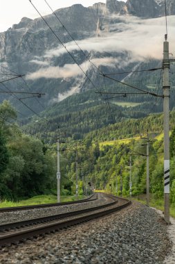 Avusturya 'nın Pfarrwerfen Avusturya yakınlarındaki güneşli yaz akşamlarında Avusturya trenleriyle elektrik hattı.