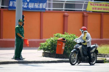 Ho Chi Minh Şehri Vietnam sokaklarında motosiklet süren bir kadın. Trafik ışıklarında durduruldu.