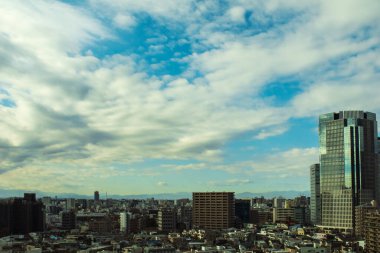 Gökyüzü, bulutlar, şehir ve binaların gündüz görüntüsü