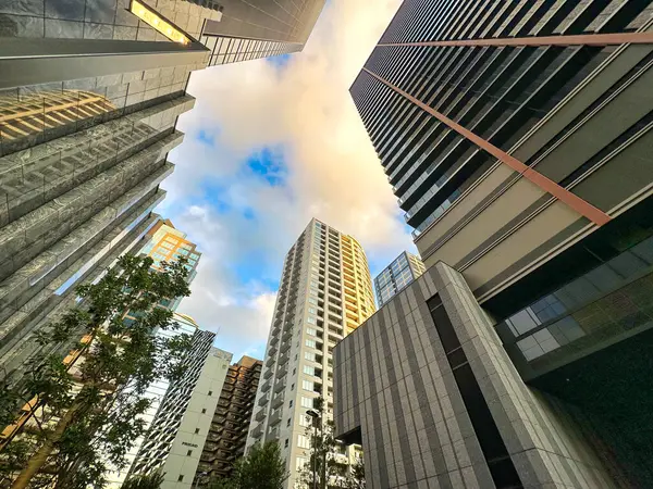 Şehirdeki yüksek binalar, mavi gökyüzü ve beyaz bulutlar, gündüz vakti