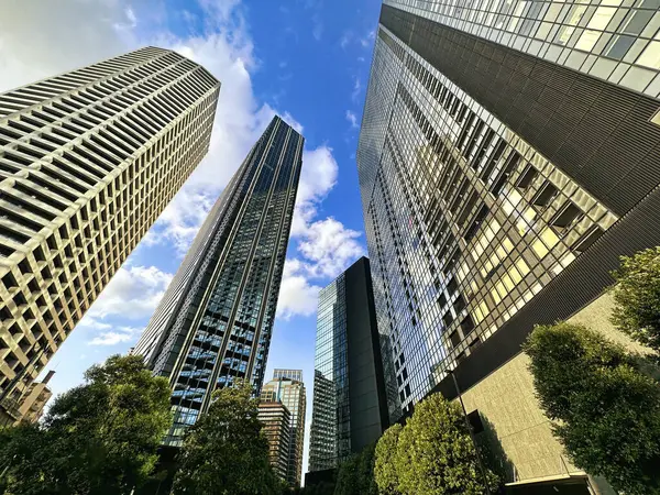 Şehirdeki yüksek binalar, mavi gökyüzü ve beyaz bulutlar, gündüz vakti