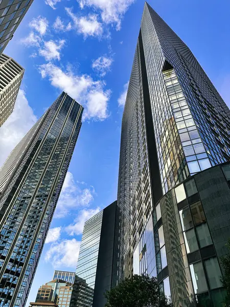 Şehirdeki yüksek binalar, mavi gökyüzü ve beyaz bulutlar, gündüz vakti