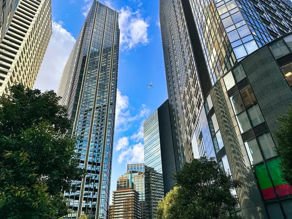 Şehirdeki yüksek binalar, mavi gökyüzü ve beyaz bulutlar, gündüz vakti