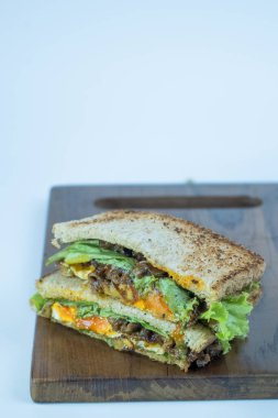 Sandviç 'i kesme tahtasına yakın çekim yap. İştah açıcı sığır eti parçaları..