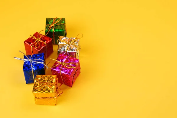 Metallic Kleurrijke Cadeaus Met Gouden Snaren Geïsoleerd Gele Achtergrond Studio — Stockfoto