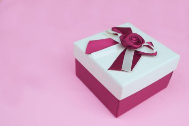 Pembe arka planda kestane rengi fiyonklu hediye kutusu stüdyo izole edilmiş.