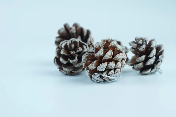 Decorational pine cones with artificial snow, isolated over the white background selected focus