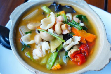 Baharatlı ve ekşi karışık sebzeler masada servis edilen beyaz seramik kasede..