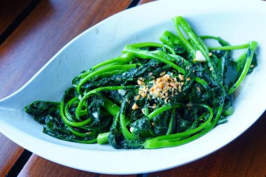 Bebek kailan masada seramik servis tabağıyla sotelenmiş..