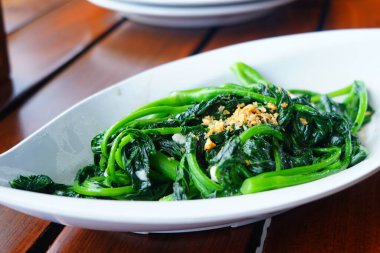 Bebek kailan masada seramik servis tabağıyla sotelenmiş..