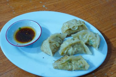 Japon goyza hamur köftesi tabakta acı biber yağıyla servis edilir. en üstteki görünüm.