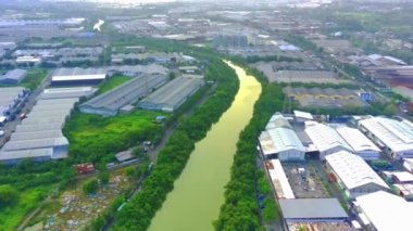 Flying over the river of Lamong East Java with the view of industrial estates by the river banks during sunset. Aerial shot.