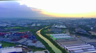 Flying over the river of Lamong East Java with the view of industrial estates by the river banks during sunset. Aerial shot.