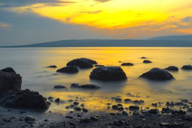 Rocks on the beach during sunrise in Banyuwangi, Indonesia. Long exposure photography. Defocused.