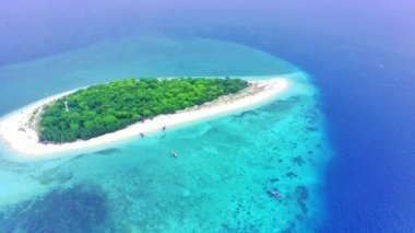 The small island named Tabuhan in the beautiful clear waters of the Bali Straits. Banyuwangi. Indonesia. Aerial footage taken with Drone.