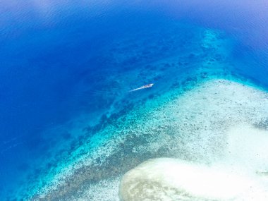 Boat sails around the Menjangan island of Bali Straits. Indonesia. Aerial Footage taken with drone.