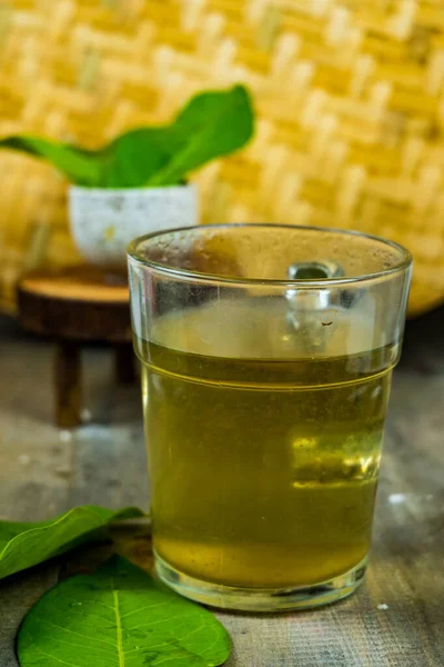 Stock image Fresh tea made of bay leaf in a glass on the table with bamboo tray background.