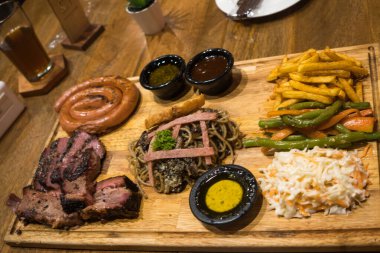 Restoranda ahşap tepside sebzeli ızgara et ve erişte..