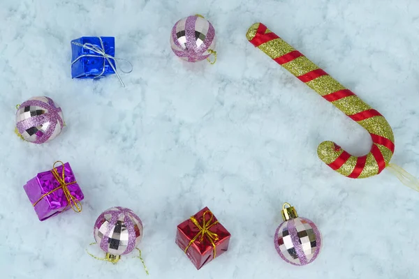 きらびやかなクリスマスの赤ちゃん 金属の文字列とカラフルなプレゼントとお菓子の杖 フルフレーム — ストック写真