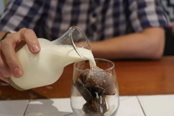 カフェのテーブルの上に置かれたミルクグラスアイスコーヒー — ストック写真